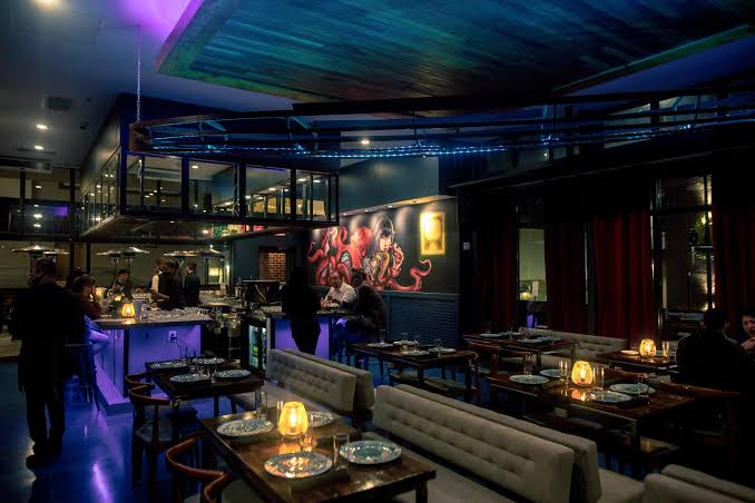 Speakeasy room with banquette seating and brass table lamps